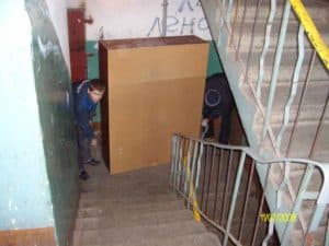 Грузчики ЯрГруз спускают шкаф по лестнице