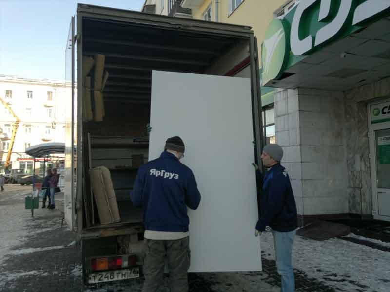 Грузчики ЯрГруз загружают офисную мебель в фургон
